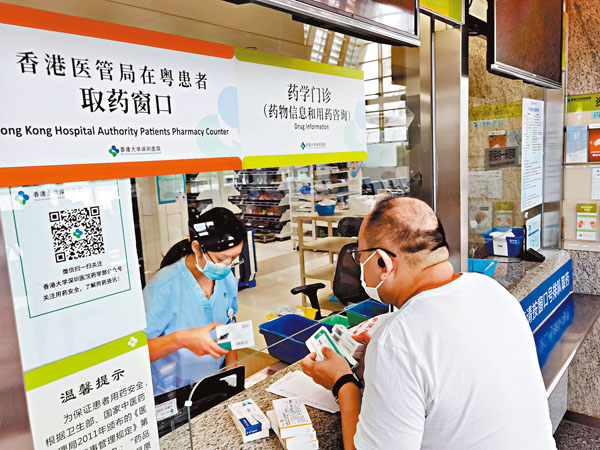 ■梁先生在取藥窗口取藥。香港文匯報記者郭若溪  攝