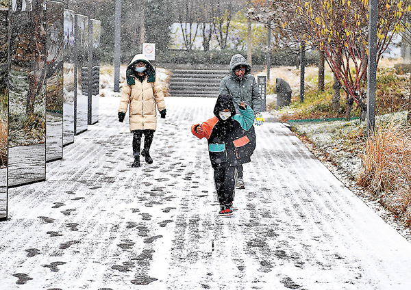 ■昨日，遊人在雪中遊覽北京首鋼園。當日，北京迎來今冬第一場雪。 新華社
