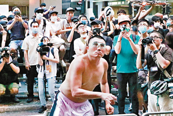 被告潘浩超當日在警察總部外不斷向警總內投擲雞蛋。 資料圖片