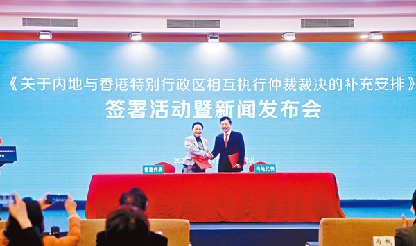 ■楊萬明（右）與鄭若驊（左）在深圳五洲賓館分別代表兩地簽署了《關於內地與香港特別行政區相互執行仲裁裁決的補充安排》。   最高法供圖
