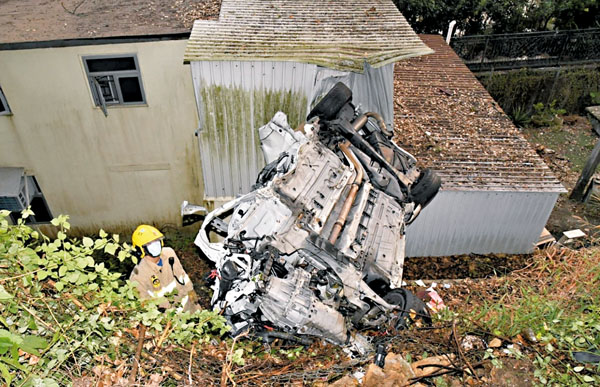 ■失事私家車飛墮山坡四輪朝天撞向村屋的鐵皮建築物。