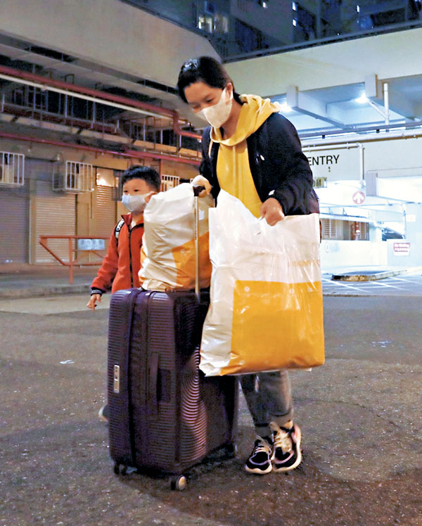 ■ 爆發群組感染的葵盛西邨,有居民連夜收拾行李帶小朋友離開。 香港文匯報記者 攝