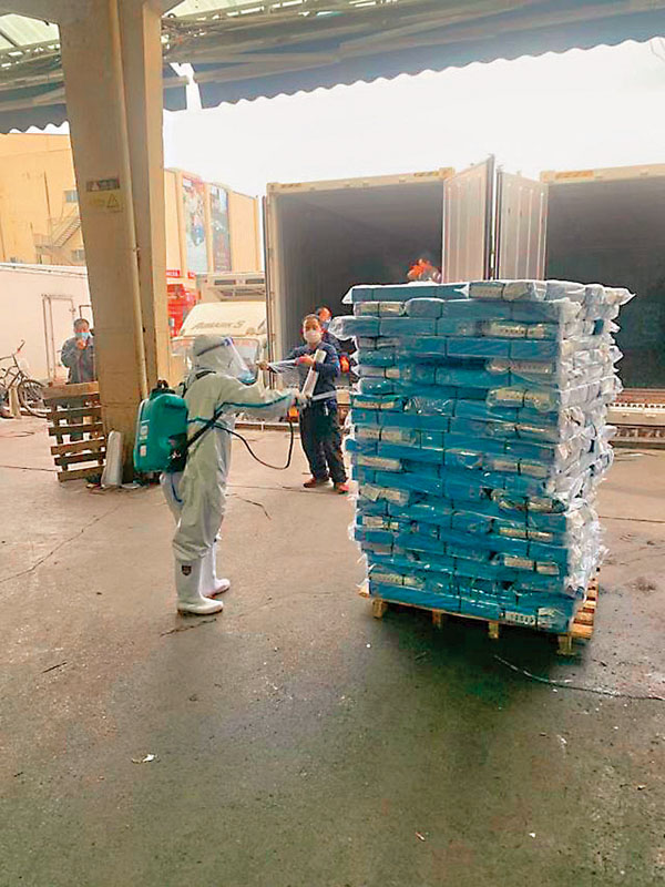 ■ 工作人員對從冷凍貨櫃中卸裝的凍品進行消毒。    受訪者供圖