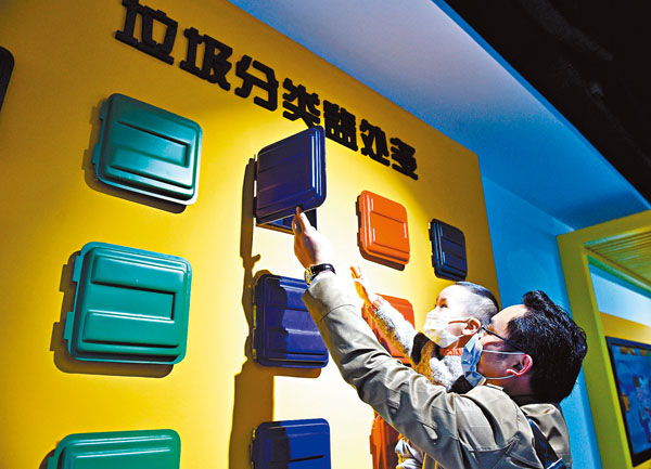 ■家長帶着小朋友在合肥市包河區生活垃圾分類科普展示館的互動區體驗。