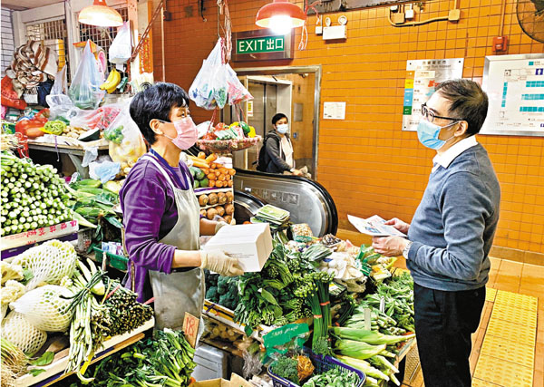 ■食環署助理署長曾永樂（右）昨日到西營盤街市，提醒街市檔販須採取各項防疫措施及遵守防疫規例。