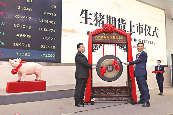 ●大連市市長陳紹旺（左）與大商所理事長冉華為生豬期貨鳴鑼開市。 受訪者供圖