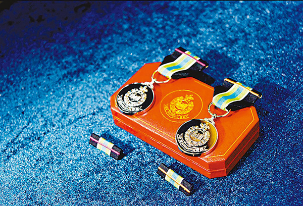 ●獎章綬帶分別繡上橙色或紫色的橫間條。 警方圖片