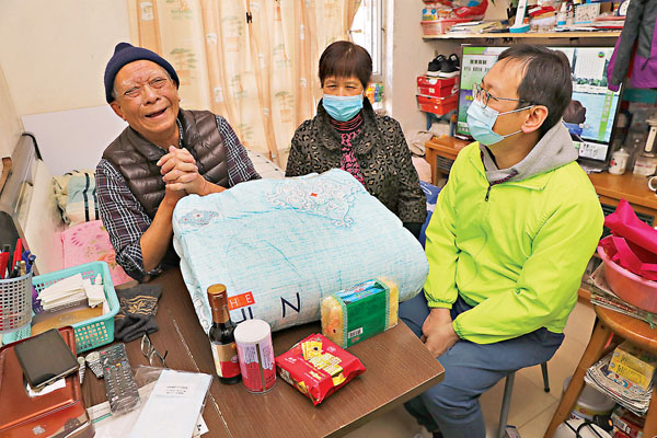 ●民建聯立法會議員柯創盛（柯仔）探訪藍田德欣樓8名獨居長者，送上棉被和福袋等讓長者在寒冬中暖身又暖心。圖為柯仔探望年過90歲的退役老兵堂伯。 香港文匯報記者  攝