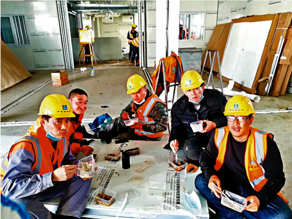 ● 逆行武漢的山東五名建築工人在火神山醫院工地吃午飯。   受訪者供圖