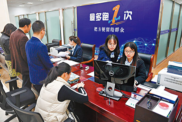 ● 今年政府工作報告提出，要提高「數字政府」建設水平。多位全國人大代表、政協委員表示，要切實落地「掌上辦」「一次辦」等舉措。圖為早年浙江省台州市行政服務中心的工作人員在給市民辦理業務。 資料圖片