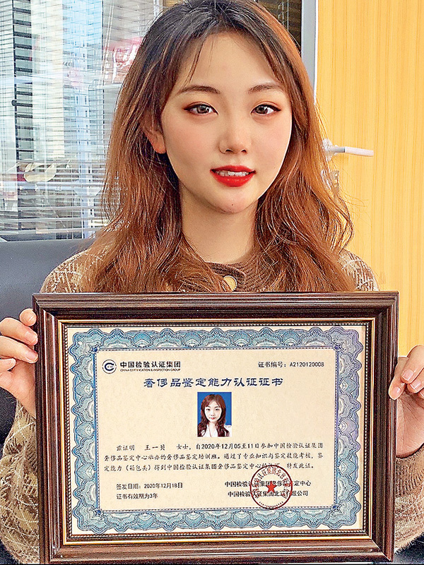 ●去年12月，王一貝赴京學習奢侈品鑒定技術。圖為王一貝手持奢侈品鑒定能力認證證書。