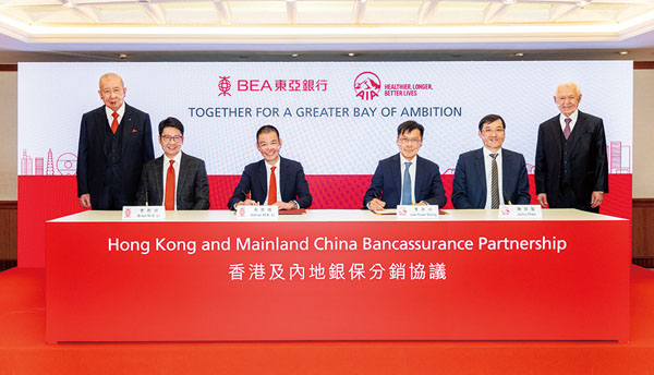 ●東亞銀行執行主席李國寶（後排左一）、友邦保險集團非執行主席謝仕榮（後排右一）、（前排左起）東亞銀行聯席行政總裁李民斌、東亞銀行聯席行政總裁李民橋、友邦保險集團首席執行官兼總裁李源祥及友邦保險集團區域首席執行官陳榮聲。