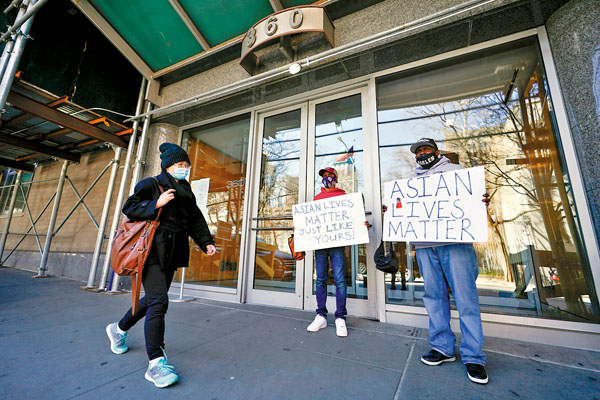 ●有人在事發大廈外聲援亞裔，手持「亞洲人的命也是命」橫額。 美聯社