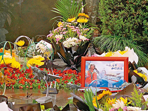 ● 殲-20、殲-15的戰鬥機與航母模型圍繞在王偉照片周圍。 香港文匯報記者俞晝  攝