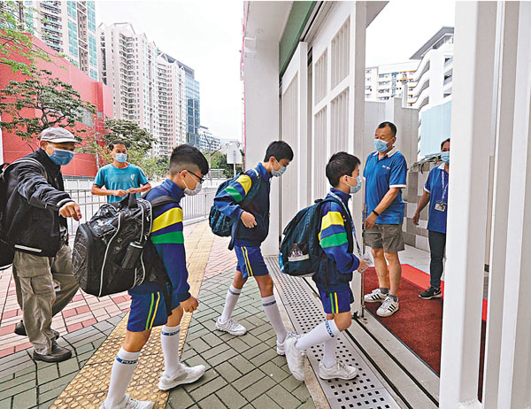 ●早前有11名學生需檢疫隔離的北角番禺會所華仁小學昨日率先復課，全校三分之二學生回校上面授課。 香港文匯報記者  攝