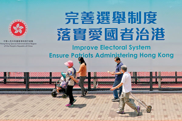 ●特區政府立法會秘書處公布，《2021年完善選舉制度（綜合修訂）條例草案》今天提交立法會作首讀及二讀。圖為香港深水街頭的「完善選舉制度  落實愛國者治港」巨幅廣告牌。 中新社
