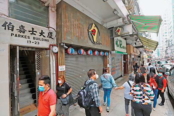 ● 住客需要隔離檢疫的伯嘉士大廈昨日大門洞開,門上未張貼檢疫告示,亦無人駐守。四間地舖關閉其三,只有一間繼續營業。 香港文匯報記者 攝