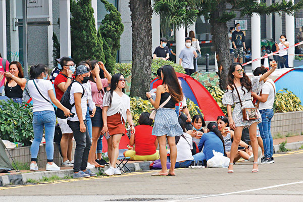 ●禁飛令下，本港菲傭供應鏈斷裂，已經身處香港的完約、斷約外傭因而成為搶手貨。圖為有十多名外傭無視疫情，搭起帳篷聚集。 香港文匯報記者  攝