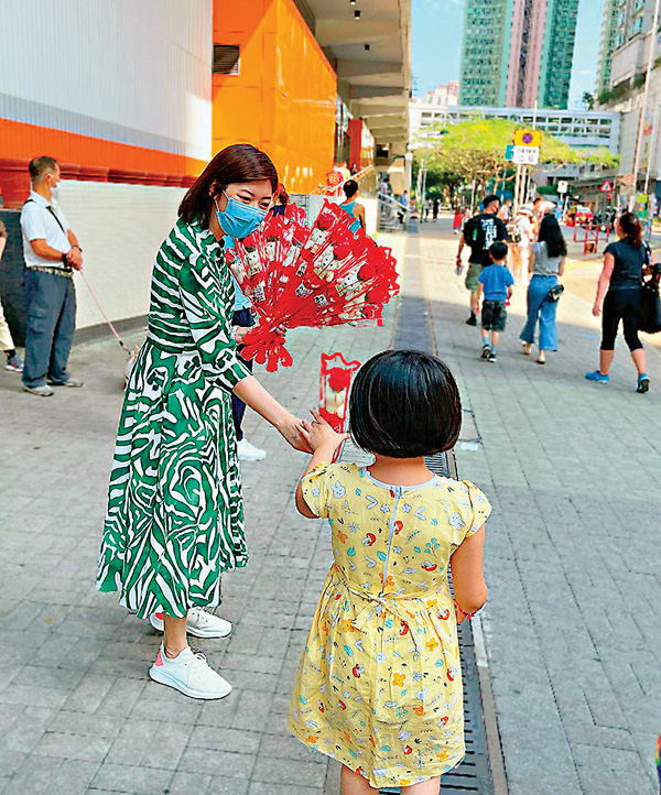 ●容海恩向小朋友派花。受訪者供圖