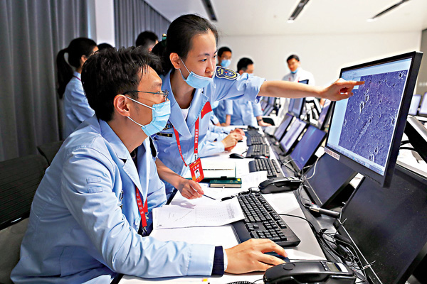 ● 航天科研人員監測「祝融號」火星車工作情況，研究傳回的火星地面高清圖片。 新華社