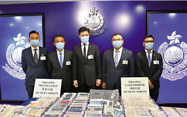 ●警方展示檢獲的現金及手提電話等證物。 香港文匯報記者  攝