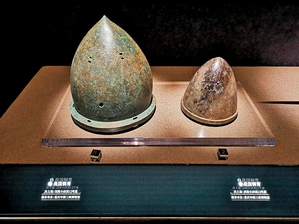 ●巴人尚武，銅胄類似今天的「鋼盔」，在冷兵器時代的戰場發揮作用，圖為展出的成人銅胄、兒童銅胄。