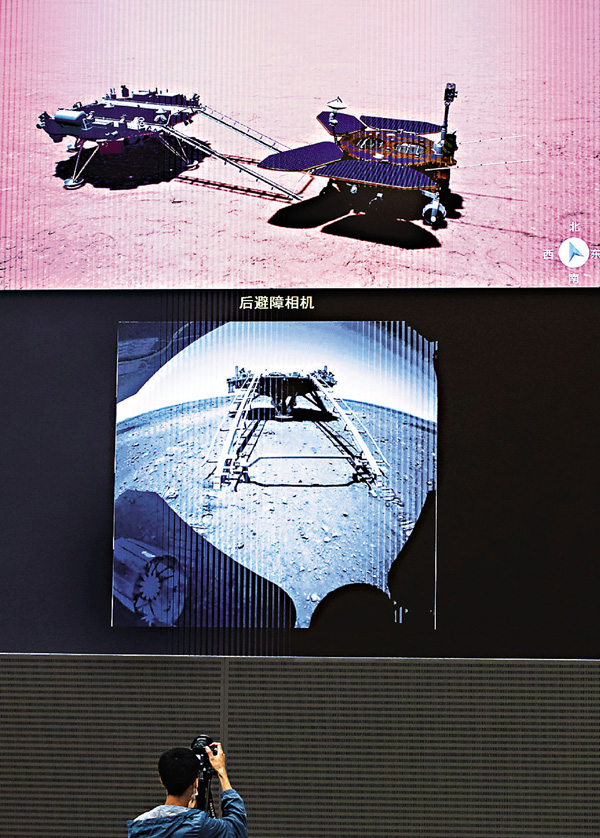 ●22日，在北京航天飛行控制中心，一名工作人員正在拍攝火星車駛離着陸平台畫面（下圖）。上圖為火星車駛離陸平台模擬圖。 新華社