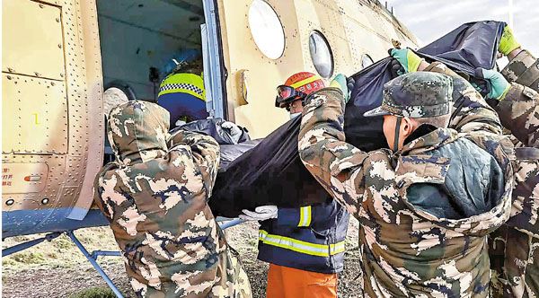 ●5月23日，救援人員將遇難者遺體搬上轉運直升機。 新華社