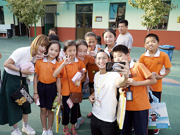 英皇集團執行董事楊政龍在父親楊受成的言傳身教下亦積極參與社會公益活動，定期組織義工團前往內地探訪學校及老年中心。