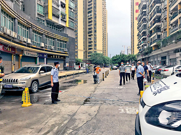 ● 東漖新村小區門口拉起了警戒線，並有警員和警車把守。香港文匯報記者盧靜怡 攝