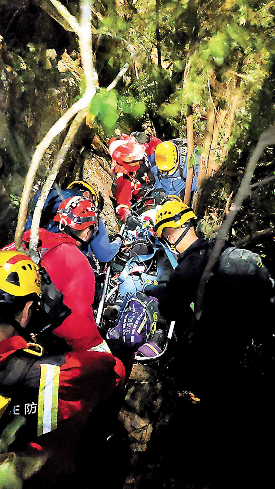 ●救援人員在發生小型山泥傾瀉後，把女傷者緊急撤離至飛行服務隊吊運點。 消防處供圖