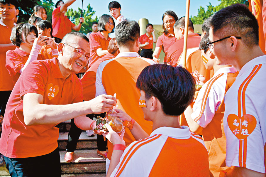 ●廣西南寧華僑實驗高中的教師派發粽子和糕點，為高三學子送上祝福。  中新社