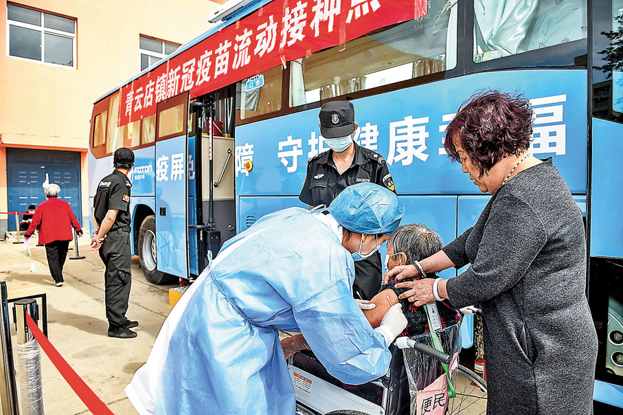 ●早前在北京大興區青雲店鎮東店村疫苗流動接種點，醫護人員下車為一位八旬老人接種疫苗。 資料圖片