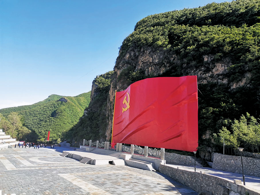 ●紀念館前依山而建的巨大黨旗。