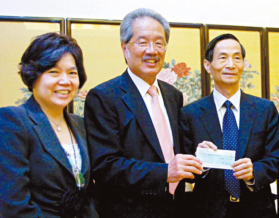 2008年，黃宜弘（中）通過中聯辦向四川地震災區捐款。 資料圖片