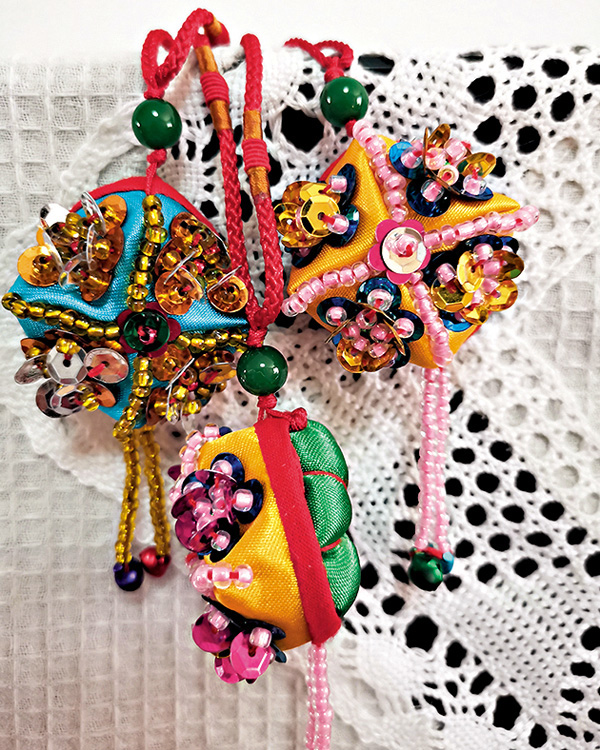 ●形似新疆四角小帽的重工串珠刺繡荷包，寓意「貌（帽）美如花」。香港文匯報記者吳千  攝