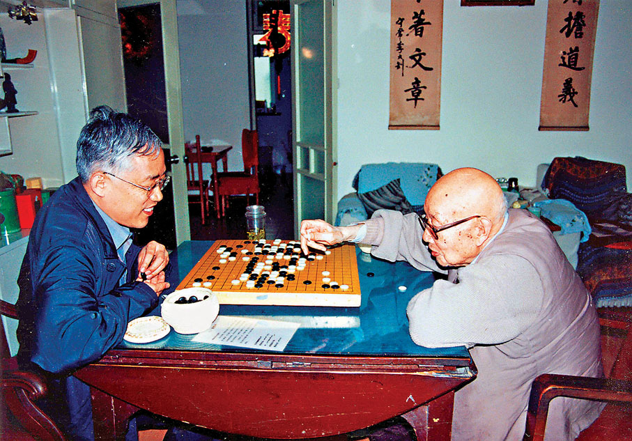 ●1990年，李宏塔（左）陪父親李葆華（右）在家中下棋。 受訪者供圖