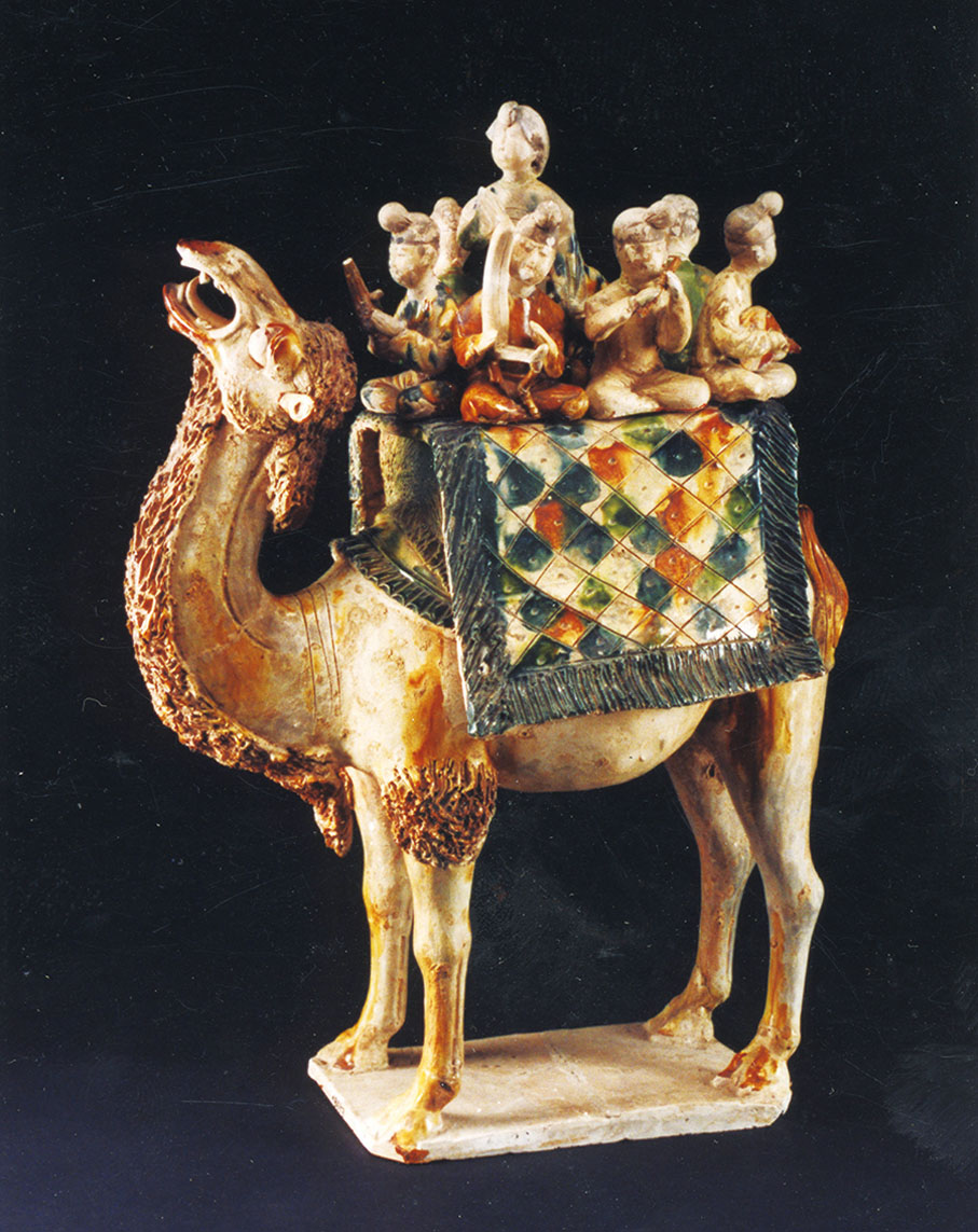 ●三彩載樂駱駝俑上，漢服男子手持胡人樂器演奏。
