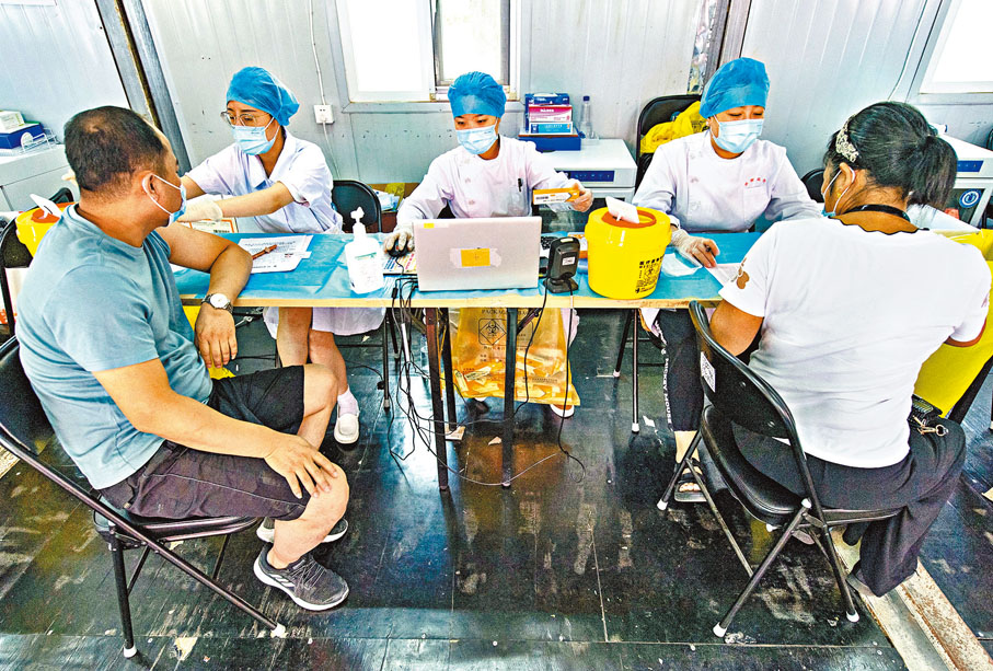 ●6月16日，北京市和天津市18歲及以上人群新冠疫苗全程接種率也已突破80%。圖為20日，市民在北京市朝陽區望京地區的一處疫苗接種點接種新冠疫苗。  中新社