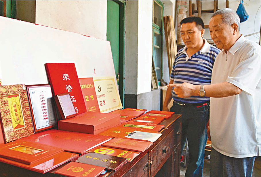 ●周永開（前）獲得的部分榮譽證書。