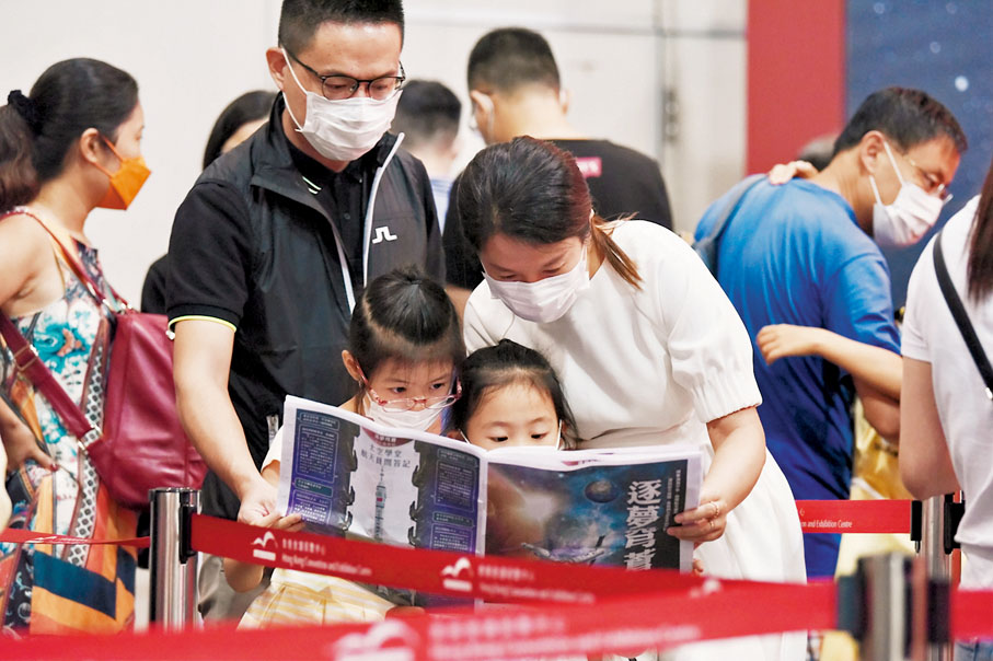 ●一家四口觀看場內刊物，了解航天科技成就。 中新社