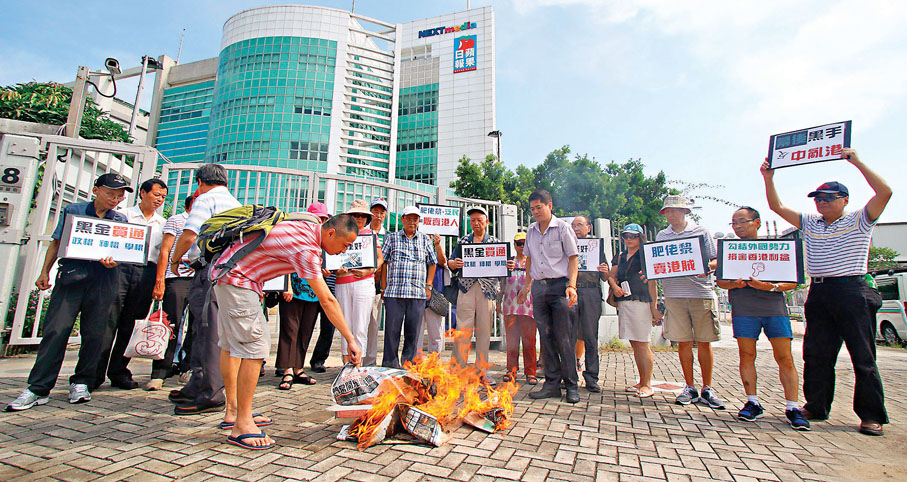 ●2014年7月有市民於壹傳媒大樓外焚燒《蘋果日報》，抗議肥佬黎勾結外國勢力反中亂港。 資料圖片