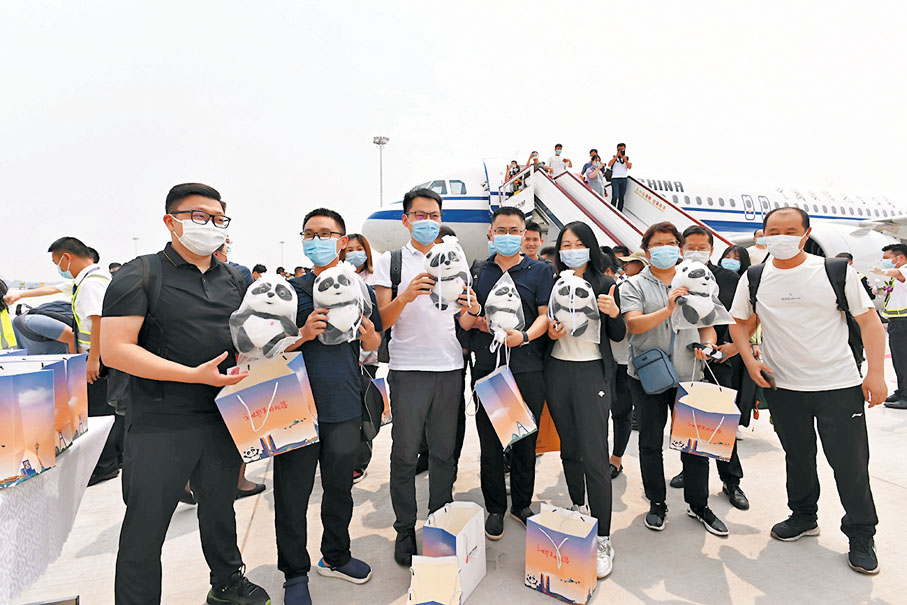 ●首批抵達天府國際機場的旅客在機坪上合影留念。  中新社
