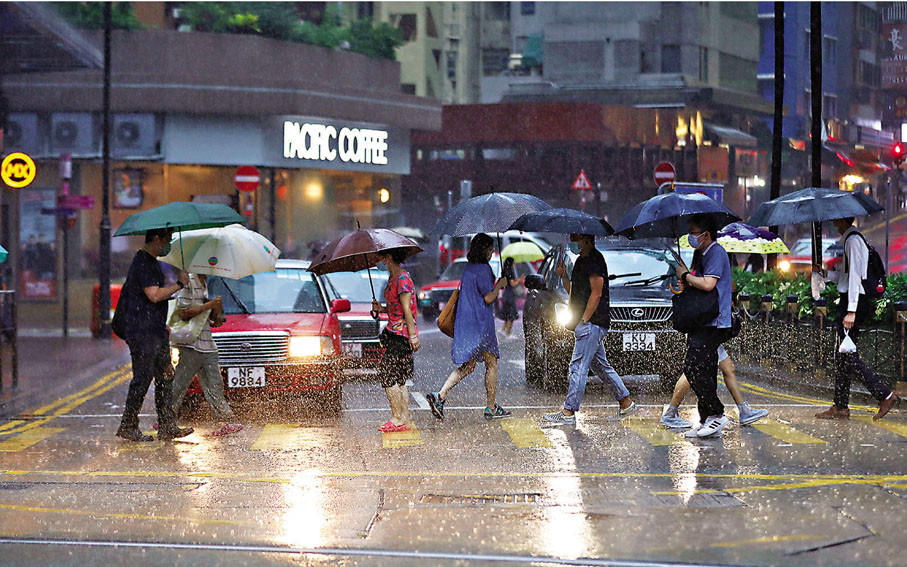 ●天文台昨晨8時20分發出今年首個黑雨警告，不少已經出門上班的市民在大雨滂沱下，狼狽不堪。 香港文匯報記者  攝