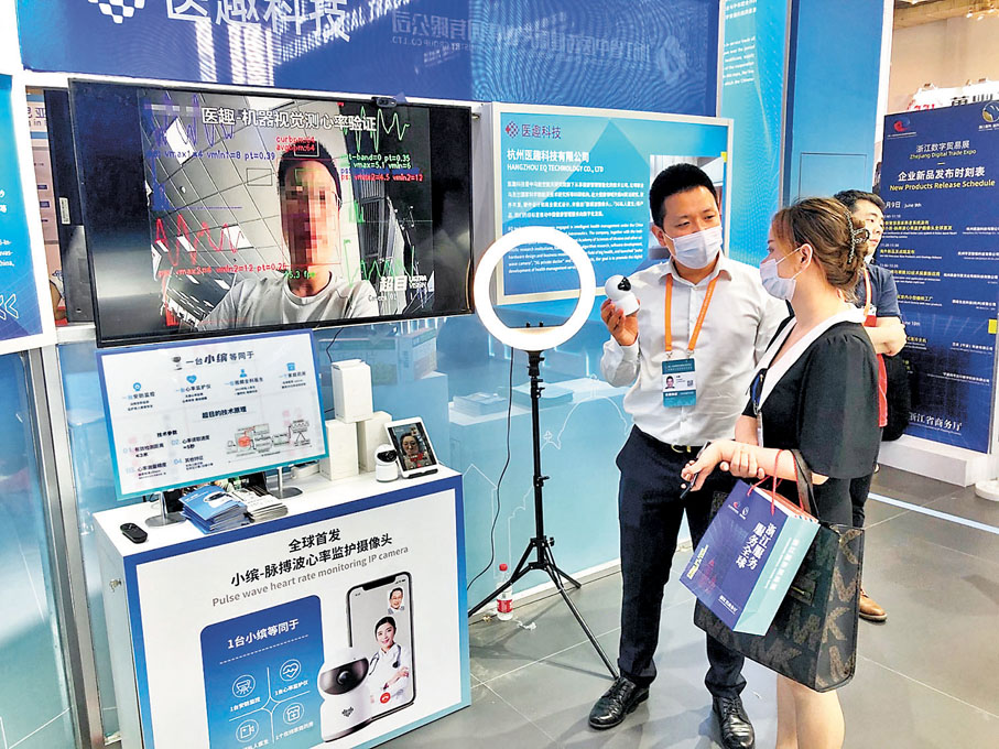 ● 醫趣科技CEO方坤（左）向客戶介紹源自烏克蘭核心技術的監測攝像頭。記者王莉  攝