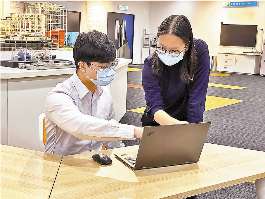 ●中華電力業務信息、數據策略及分析經理郭芝華(左二）向實習生吳浩天（左一）提供工作建議。 香港文匯報記者  攝