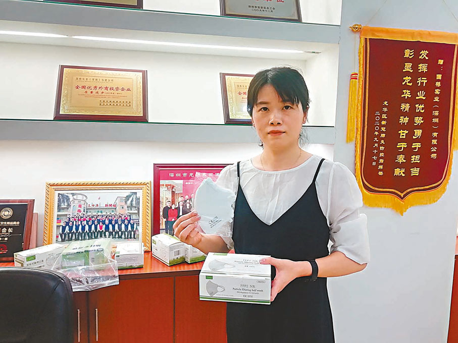 ● 國橋工作人員向記者展示公司生產的口罩。