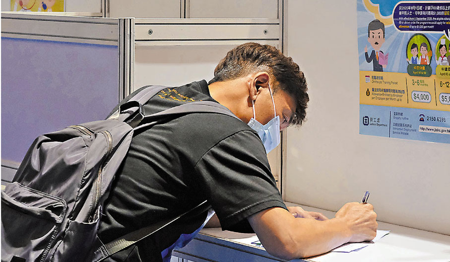 ● 一名求職者現場填寫應徵表格提交。 香港文匯報記者 攝