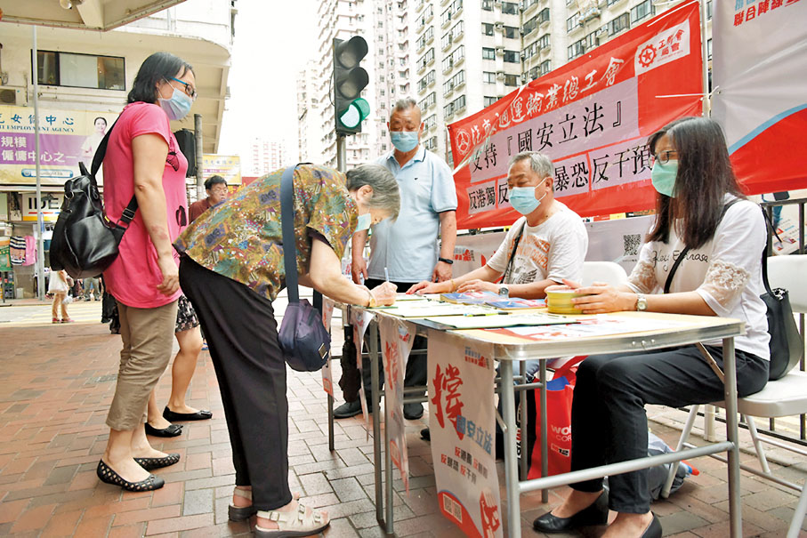 ●愛國愛港人士自發舉行簽名活動，宣傳推廣香港國安法，圖為有長者到街站簽名支持。 資料圖片