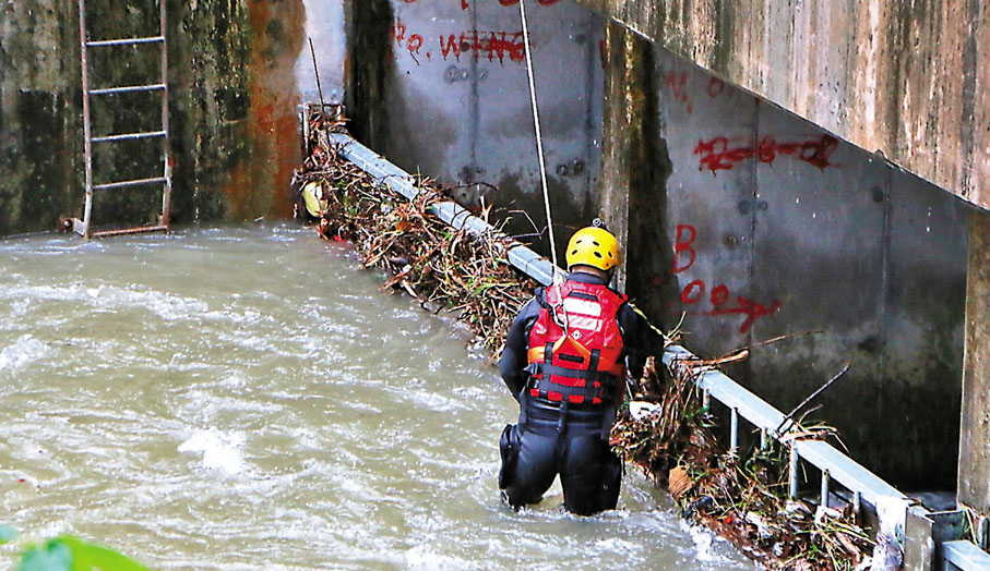 ● 昨午天氣稍為好轉後，消防潛水員隨即在集水區進行搜索。香港文匯報記者  攝